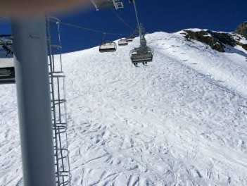 View from the chairlift toward an open, unmarked snow slope