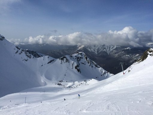 Snow-covered peaks of the Caucasus Mountains above Krasnaya Polyana, Russia, under a bright sky