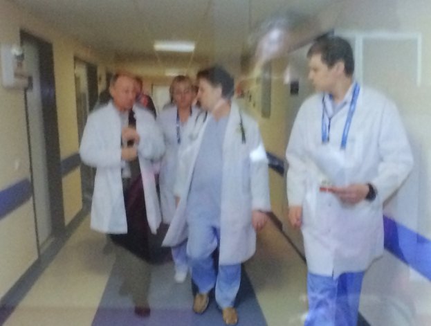 Blurred photograph of doctors in white coats walking down a hospital corridor